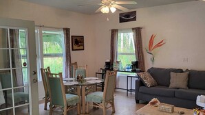 A living room with a dining area, a sofa, a coffee table, and a ceiling fan. - Hoomaikai Blessing's (Keaau)