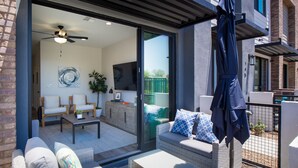 A modern patio area with wicker furniture, a ceiling fan, and a sliding glass door leading to an indoor living space. - 3 Bedroom Townhome in the heart of downtown Gilbert, AZ - Lot 30 (Gilbert)