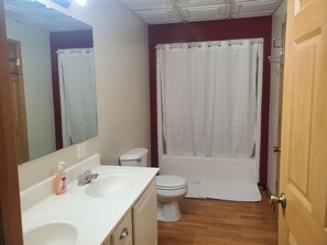 Un baño con lavamanos, inodoro y bañera blancos.