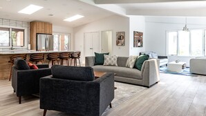 A spacious living area with a grey sofa, black armchairs, and a wooden dining table. - Modern Sedona Escape Rooftop Views, Trails Nearby, Pet Friendly (Sedona)
