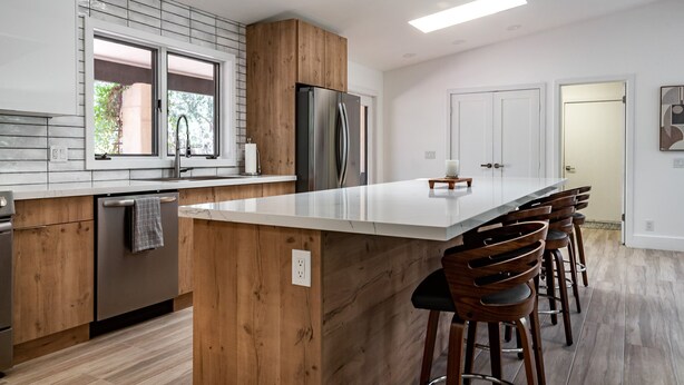 A modern kitchen with a central island, wooden cabinetry, stainless steel appliances, and a large window. - Modern Sedona Escape Rooftop Views, Trails Nearby, Pet Friendly (Sedona)