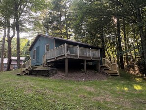 Een chalet met een houten terras en een trap naar een overdekte veranda.