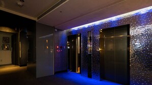 A hallway with two elevators, one of which has a mirrored wall. - Hotelshere Taipei (Taipei)