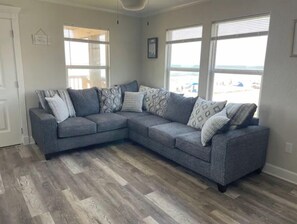 Relax in this inviting living space with a comfortable sofa, dining table, and framed artwork.