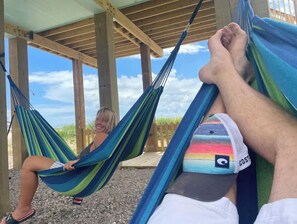 Relax in a hammock under a covered roof, surrounded by natural surroundings.