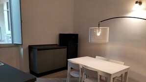 Eine kompakte Küche mit Essbereich, einem integrierten Fernseher und einer Pendelleuchte.