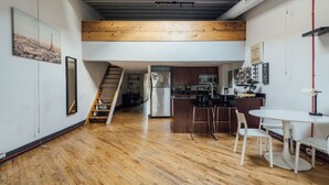 A modern loft apartment with a kitchen, dining area, and a staircase leading to a loft space. - 307 - BUILDING · ☆ RARE 4 STORY TOWNHOUSE FOR GROUPS ☆ (Philadelphia)
