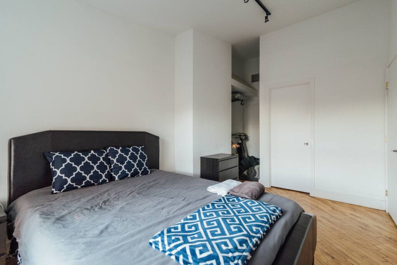 Ein modernes Schlafzimmer mit Bett, Kommode und Kleiderschrank.