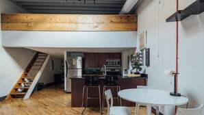A modern kitchen with wooden beams, a central island, and a dining area with white chairs. - ☆ LUXURIOUS OLD CITY PENTHOUSE ☆ (Philadelphia)