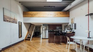 A modern kitchen with wooden flooring, a central island, and a dining area with white chairs. - ☆ LUXURIOUS OLD CITY PENTHOUSE ☆ (Philadelphia)