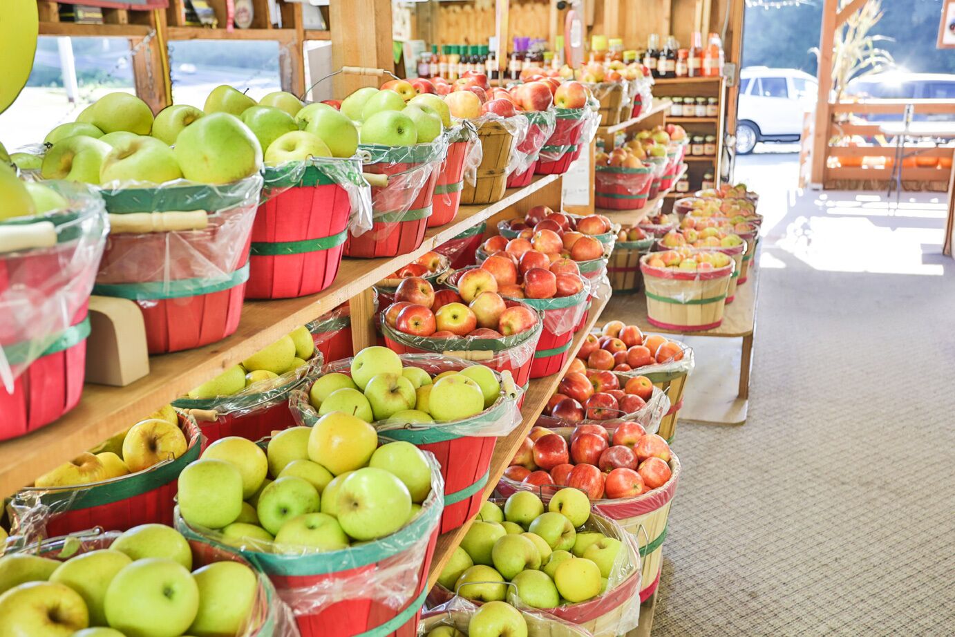 Een supermarkt met verschillende soorten fruit, tentoongesteld op planken en in manden.