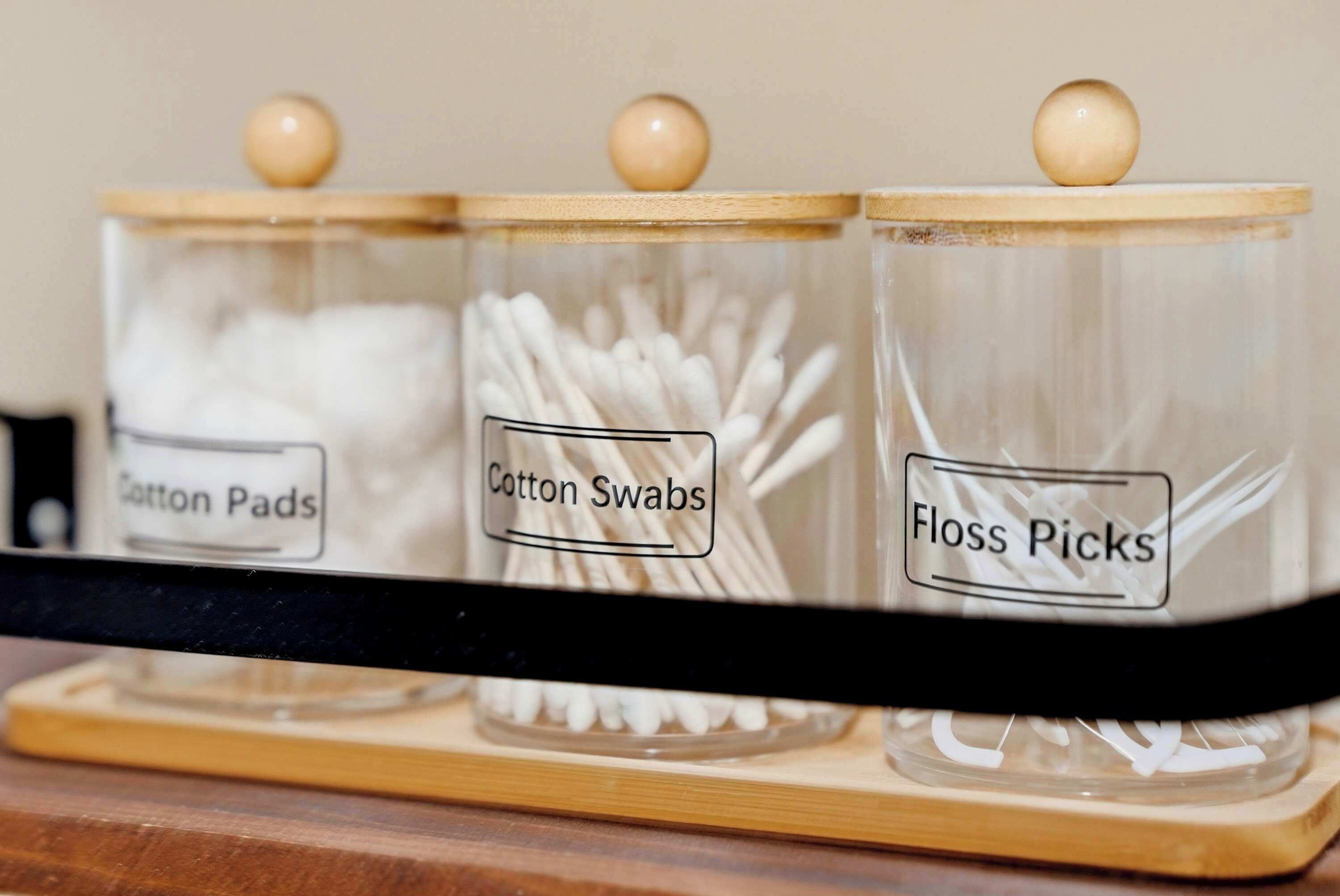 Three labeled glass jars on a wooden tray.