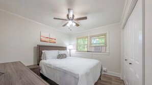 A bedroom with a bed, a desk, a ceiling fan, and a window with blinds. - Modern Seaside Condo, 2 Blocks to Sand+ Parking - a Seaside Heights Sanctuary! (Seaside Heights)