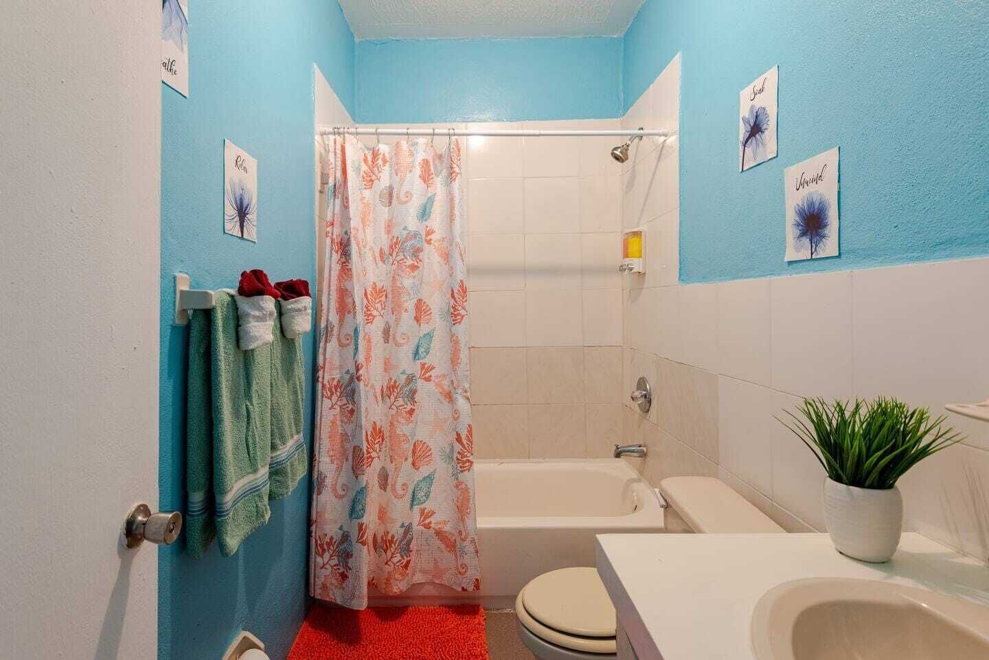 Ein Badezimmer mit Dusche, Toilette und Badewanne.