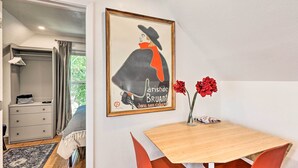 Une chambre d’hôtel avec un lit, une table de chevet, un tableau encadré et une fenêtre avec des rideaux.