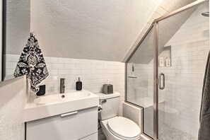 Ein modernes Badezimmer mit Waschbecken, Toilette und Duschkabine aus Glas.