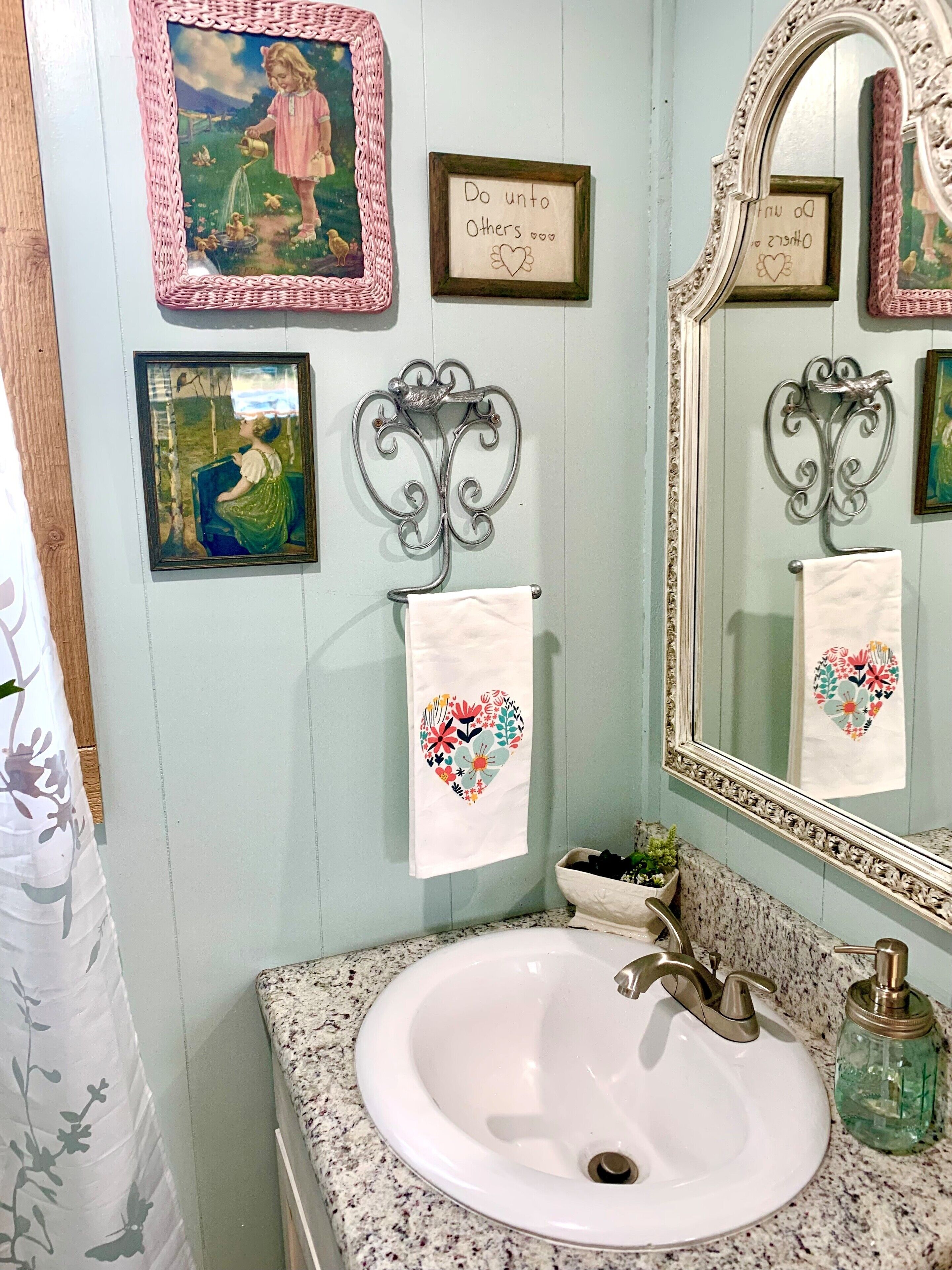 Ein Badezimmer mit Waschbecken, Spiegel und Wanddekoration.