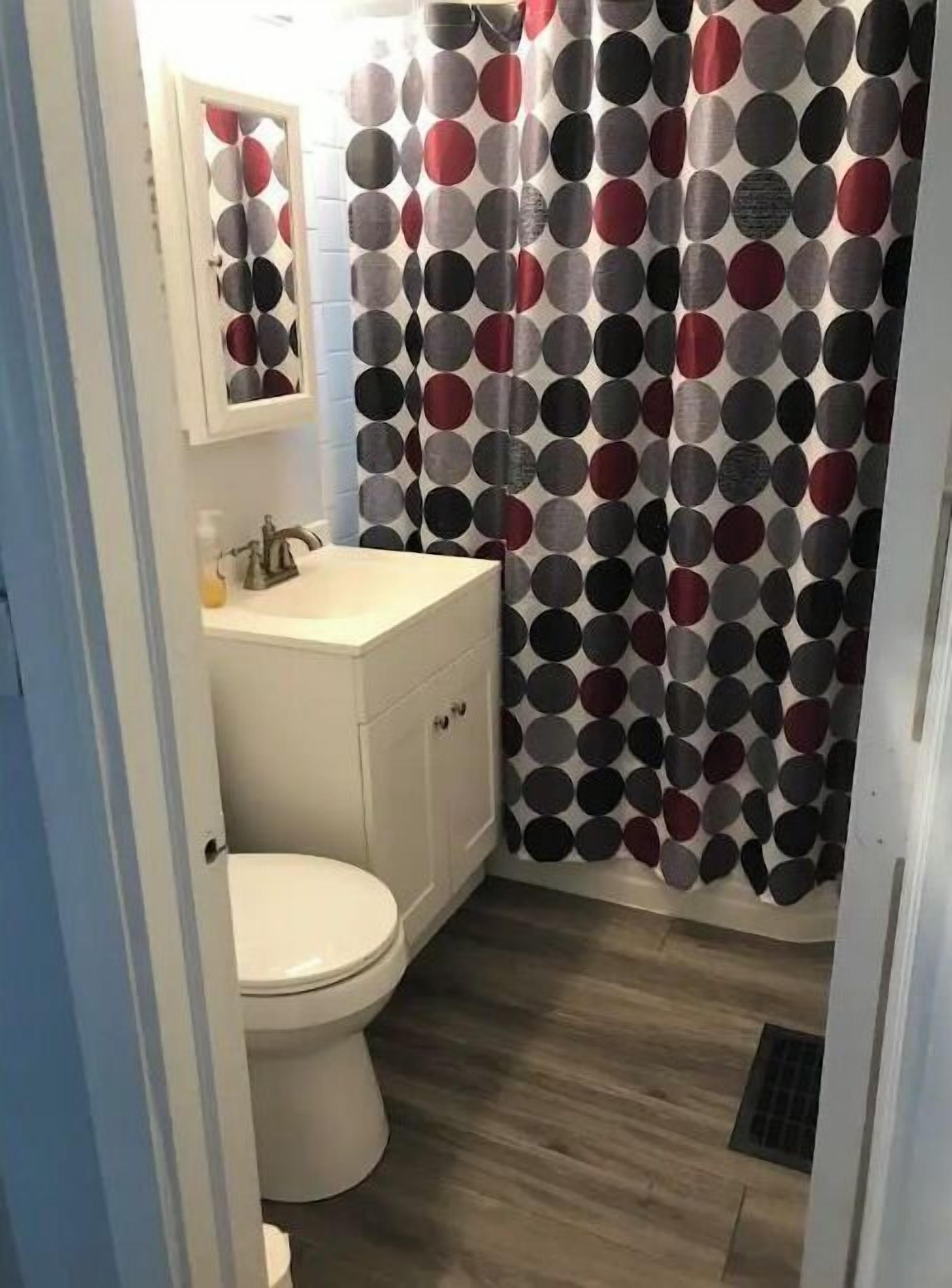 Een badkamer met toilet, wastafel en spiegel.