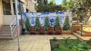 A courtyard with a tiled floor, a set of stairs, and a row of wicker chairs. - Lovely 2-bedroom apartment with free parking. (Тошкент)