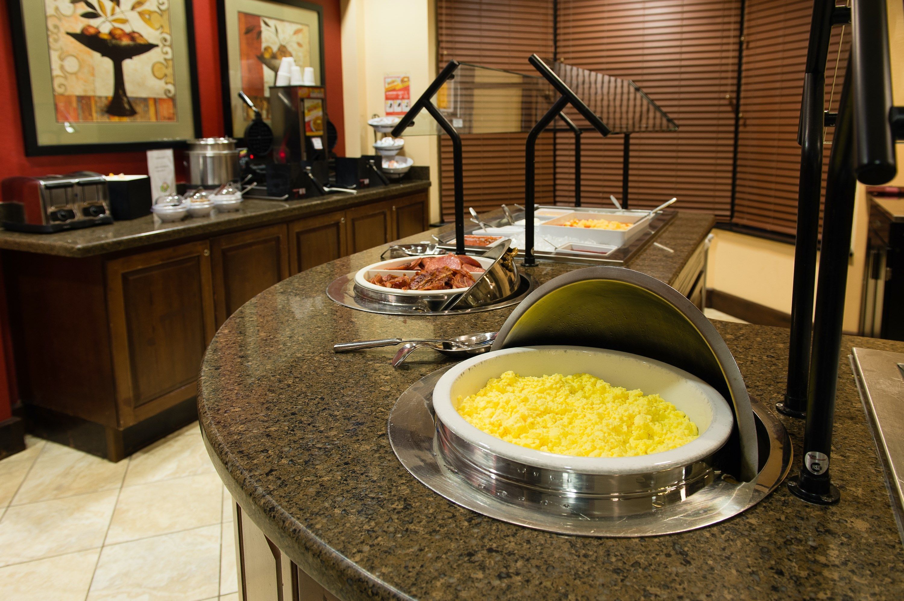 A buffet setup with various food items and a coffee station.