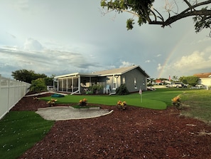 A house with a covered porch, a lawn, and a flagpole. - Coastal Coconut Cove near Anna Maria Island (Bradenton)