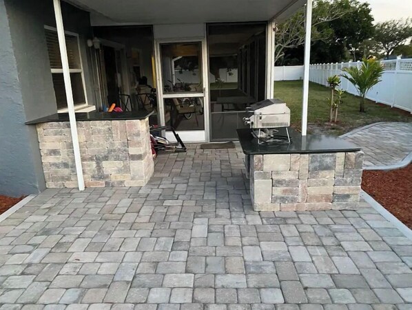 An outdoor patio area with stone planters and a grill.