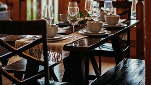 A wooden dining table set with white bowls, glasses, and a candle holder. - Endless Views - King Beds - Close to attractions ! (Sevierville)