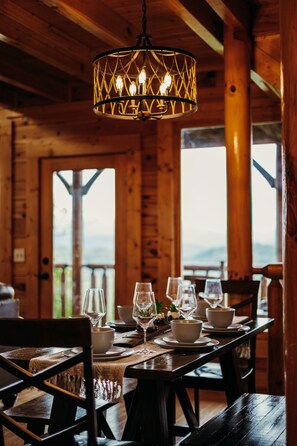 A wooden dining table set with white bowls, glasses, and a candle holder. - Endless Views - King Beds - Close to attractions ! (Sevierville)