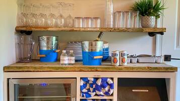 A kitchen counter with shelves holding glassware, a first aid kit, and a sign that says "family."