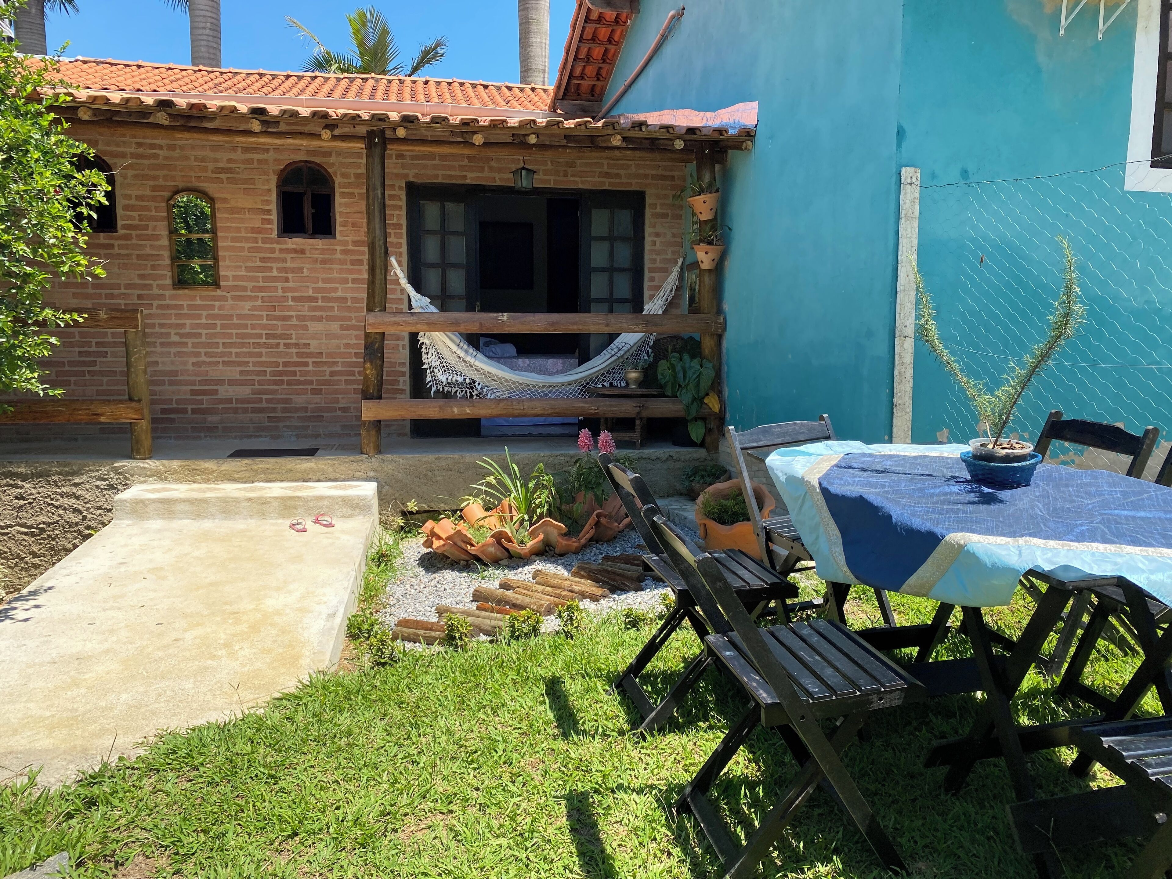 A patio with a hammock, outdoor seating, and a table with a blue tablecloth.