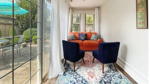 A narrow room with a large window, a blue sofa, two chairs, and a patterned rug. - Lovely 3 Bdrm Home w/Free Parking Close to I-75! (Lexington)