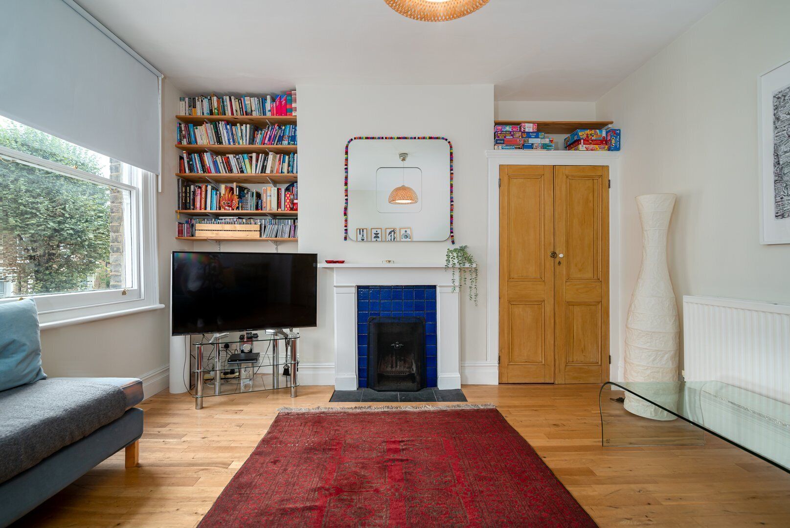 A living room with a fireplace, bookshelves, a TV, and a sofa.