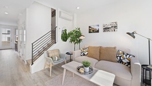 A modern living room with a staircase, a sofa set, a coffee table, and a floor lamp. - Cheerful 3-bedroom New Townhouse near UW/Seattle Children's, Free Parking, AC (Seattle)