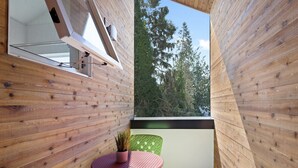 A wooden balcony with a small table and chairs, a potted plant, and a view of trees. - Cheerful 3-bedroom New Townhouse near UW/Seattle Children's, Free Parking, AC (Seattle)