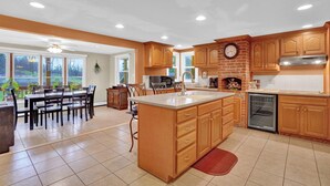 A spacious kitchen with wooden cabinets, a large island, and a dining area with a table and chairs. - Family Friendly Home w/ Large 1 Acre Backyard & Decks (Peach Bottom)