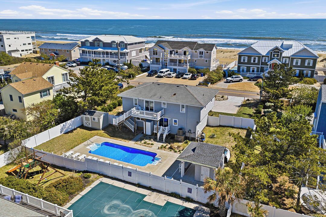 Un quartier résidentiel doté d’une grande piscine, de maisons situées en bord de mer et offrant une vue sur l’océan.