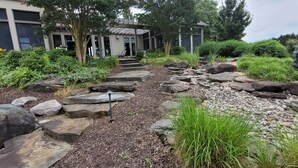 A landscaped garden with a stone pathway leading to a building entrance.