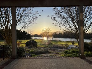 Un espacio al aire libre techado con vistas a un lago y árboles.