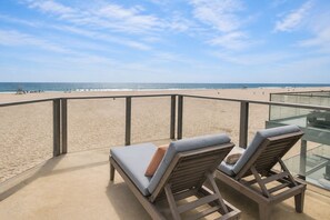 Un balcón con dos sillones de descanso con vista a la playa.