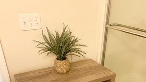 A wooden shelf with folded towels and a potted plant. - New Listing! Beautiful 2000 Square Foot Multi-Level Townhome. 1 BLOCK FROM BEACH (Seaside Heights)