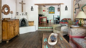 Un salon rustique, avec des meubles en bois, une cheminée et une vue sur la cuisine.