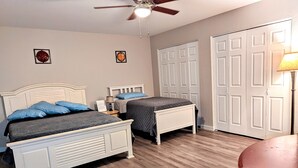 Ein Schlafzimmer mit zwei Betten, einem Deckenventilator und einem Kleiderschrank.