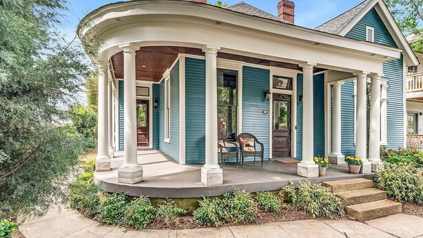 A house with a covered porch, columns, and a front door.