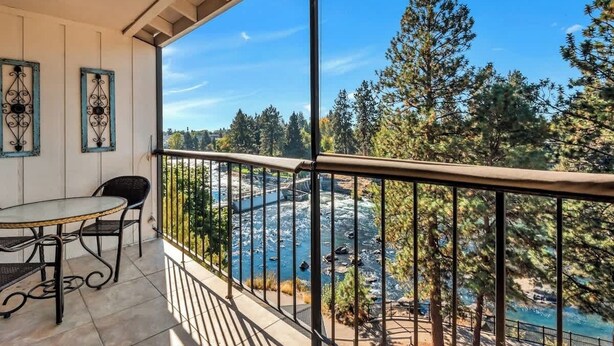 A balcony with a view of a river and trees.