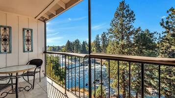 A balcony with a view of a river and trees.