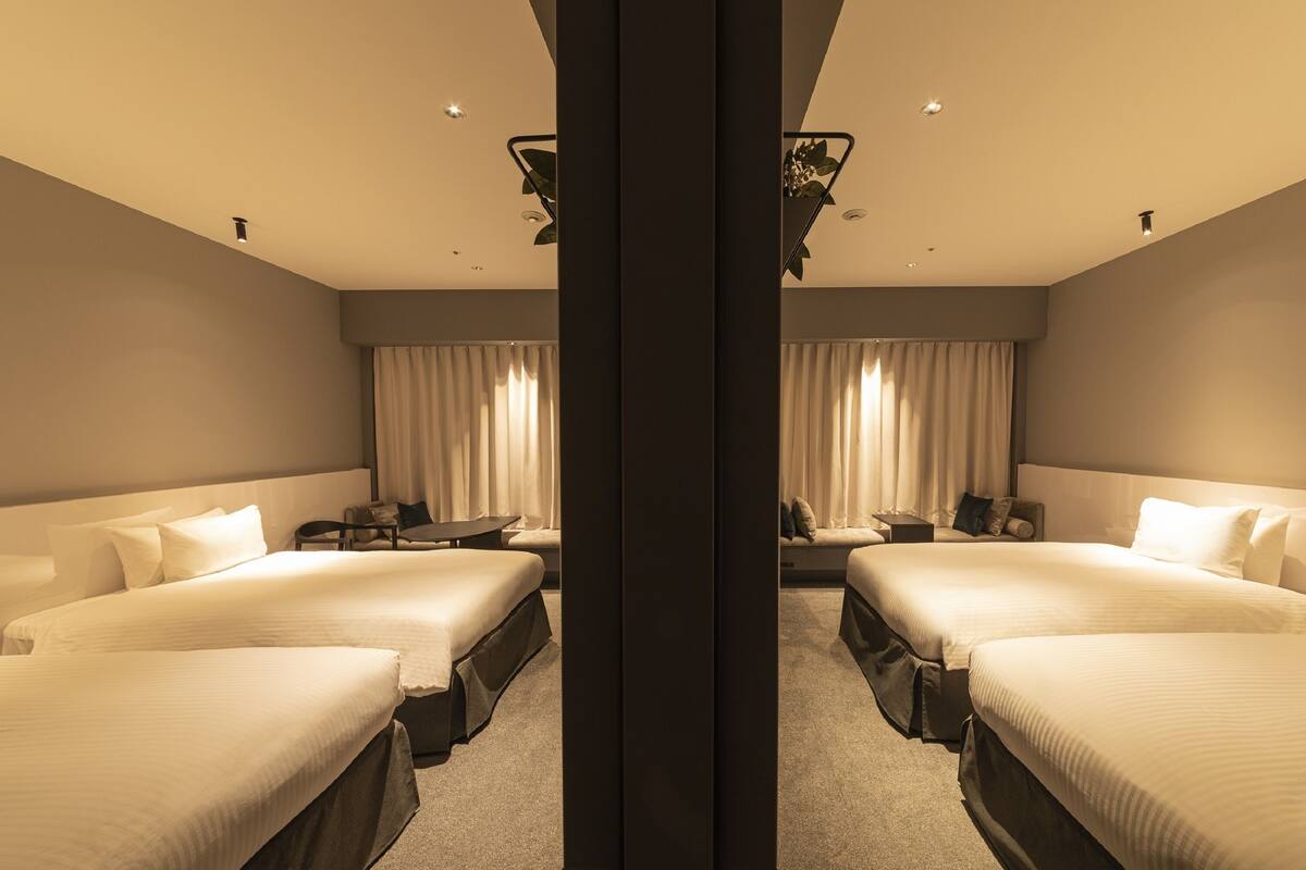 Une chambre d’hôtel avec deux lits, un bureau et une chaise.