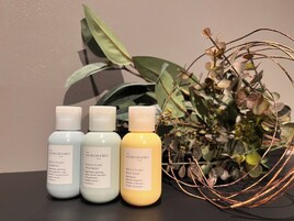 Tres botellas de productos NEMOHAMO sobre una mesa, con una planta de fondo.