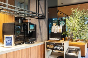 L’intérieur d’un café moderne, avec une machine à café, un espace salon et l’image de marque de Starbucks.