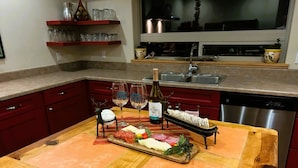 A kitchen with a wooden island, red cabinets, and a stainless steel dishwasher. - Xterra Championship Availability, Game Room, Sleeps 10 and Pet Friendly! (Ruidoso)