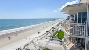 Un hotel frente a la playa con vista al océano, un muelle y una zona de piscina.